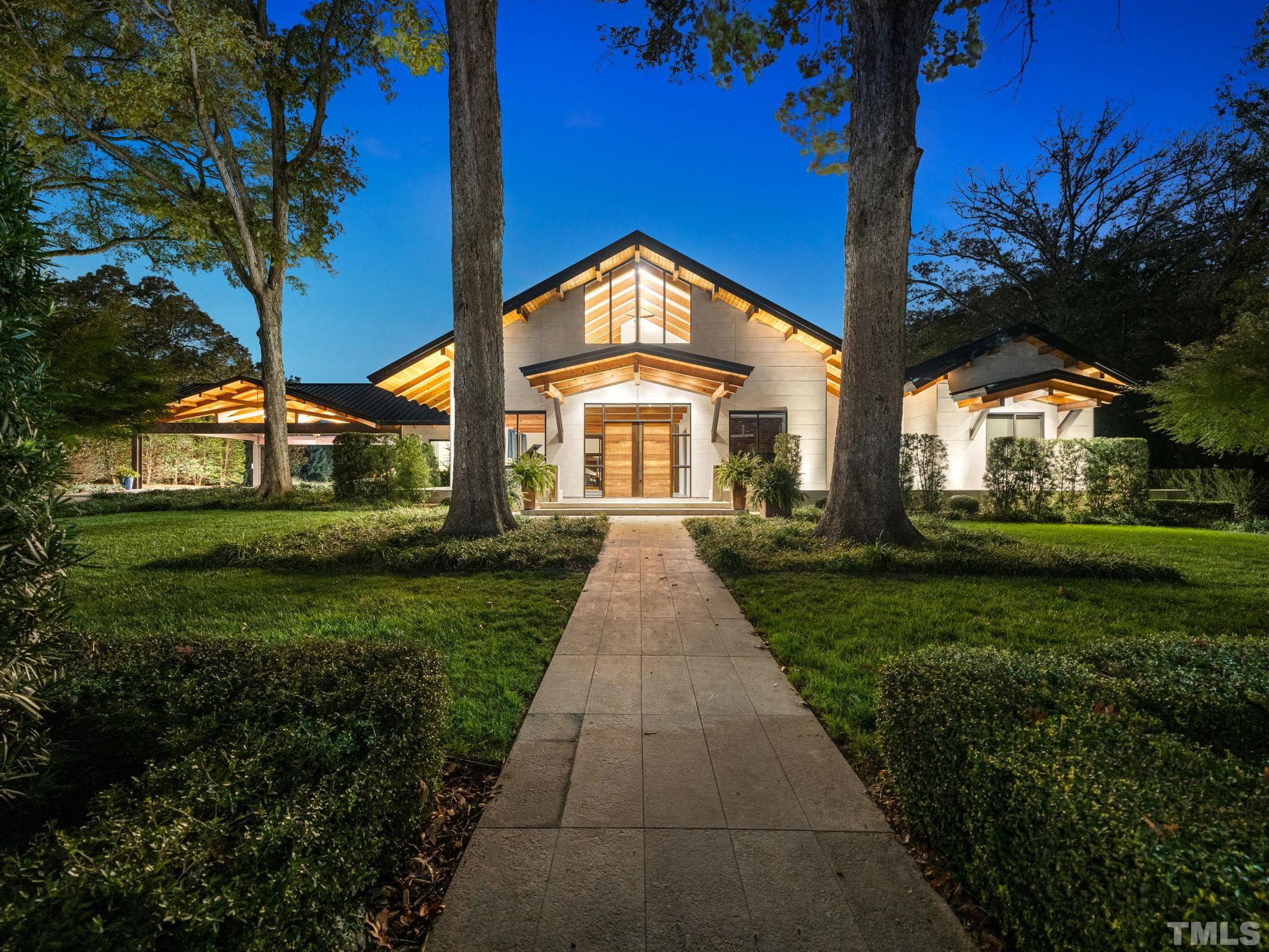 a view of a big house with a big yard and potted plants