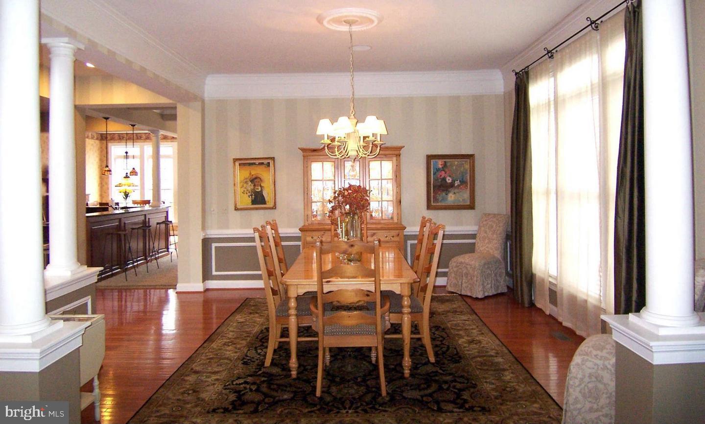 19123 Stream Crossing Court Leesburg, VA 20176 - Photo 9 of 30 a dining room with furniture a chandelier and wooden floor