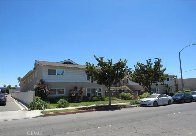 a front view of a house with a garden and plants