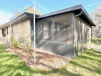 3416 Primrose Trail Georgetown, TX 78628 - Photo 6 of 35 View of home's exterior with a sunroom, a lawn, and stone siding