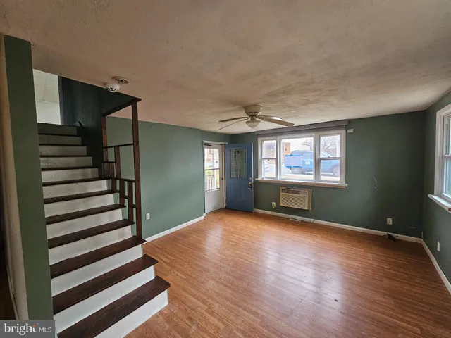a view of a livingroom with wooden floor and stairs