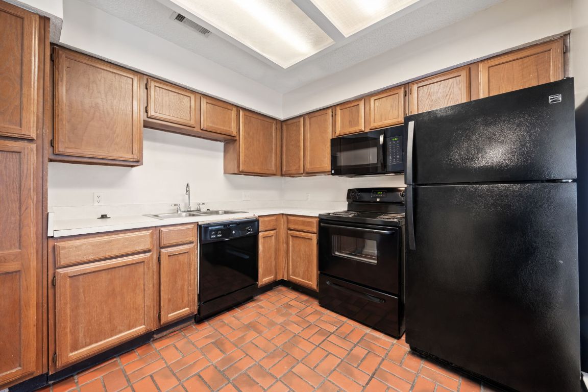2110 Rio Grande Street, Unit 306 Austin, TX 78705 - Photo 2 of 10 a kitchen with a refrigerator sink and cabinets