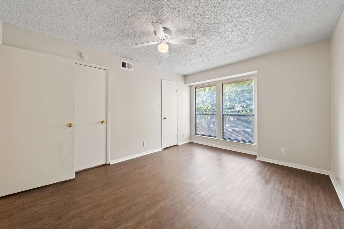 2110 Rio Grande Street, Unit 306 Austin, TX 78705 - Photo 5 of 10 a view of an empty room with wooden floor and a window