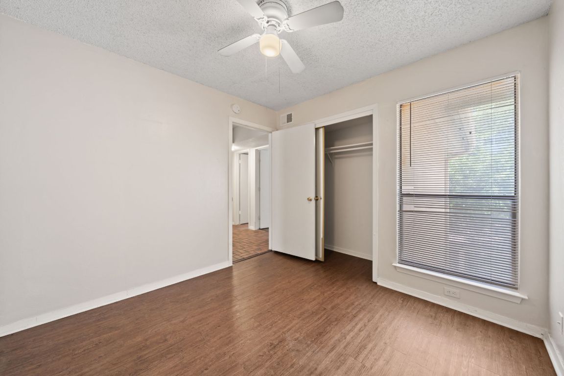 2110 Rio Grande Street, Unit 306 Austin, TX 78705 - Photo 6 of 10 an empty room with wooden floor cabinet and windows