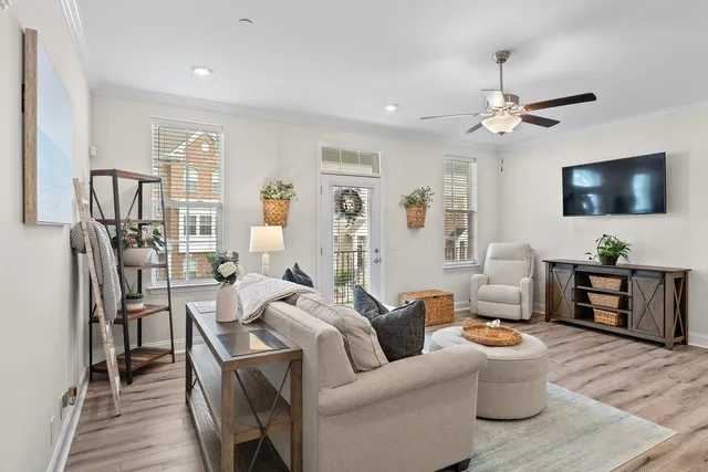 a kitchen with stainless steel appliances a refrigerator a stove a sink a dining table and chairs with wooden floor