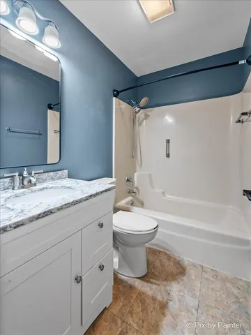 a bathroom with a granite countertop toilet a sink and a bathtub