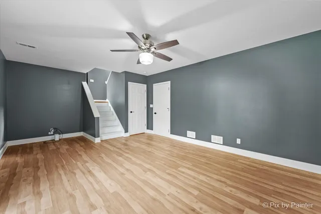 a view of a big room with wooden floor and windows