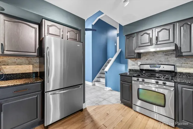 a kitchen with a stove top oven and refrigerator