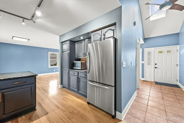 a kitchen with granite countertop a refrigerator and a stove top oven