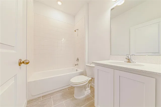 a bathroom with a toilet a sink a mirror a bathtub and vanity