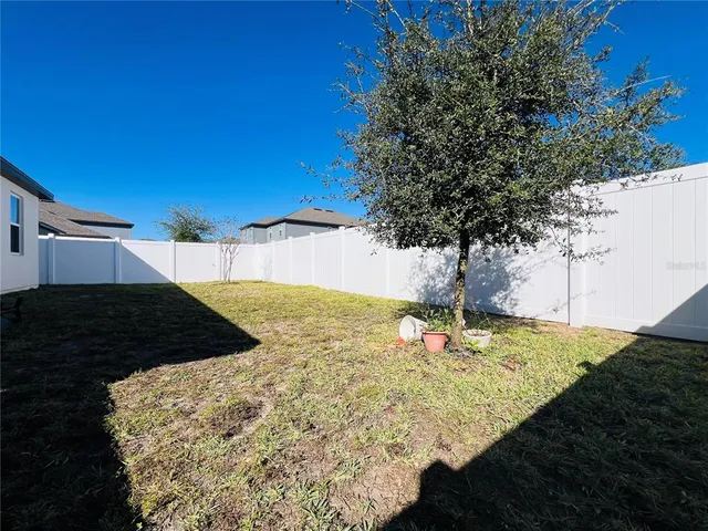 a view of swimming pool with outdoor seating and trees in the background