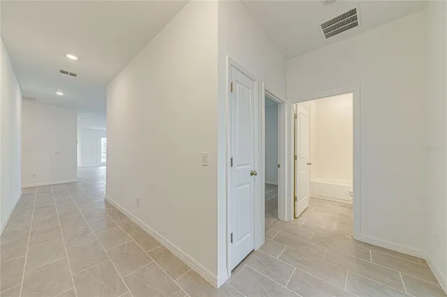 a view of hallway with a bathroom and a shower