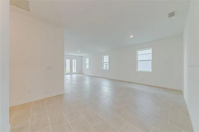 an empty room with windows and entrance