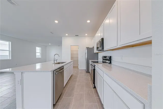 a kitchen with white cabinets and stainless steel appliances