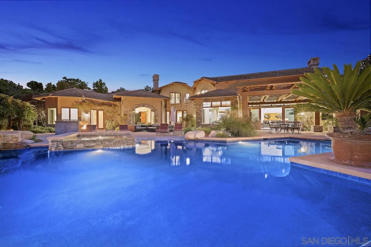 a view of swimming pool with outdoor seating and house in the background