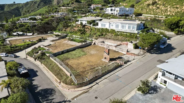 an aerial view of a house with a yard and lake view