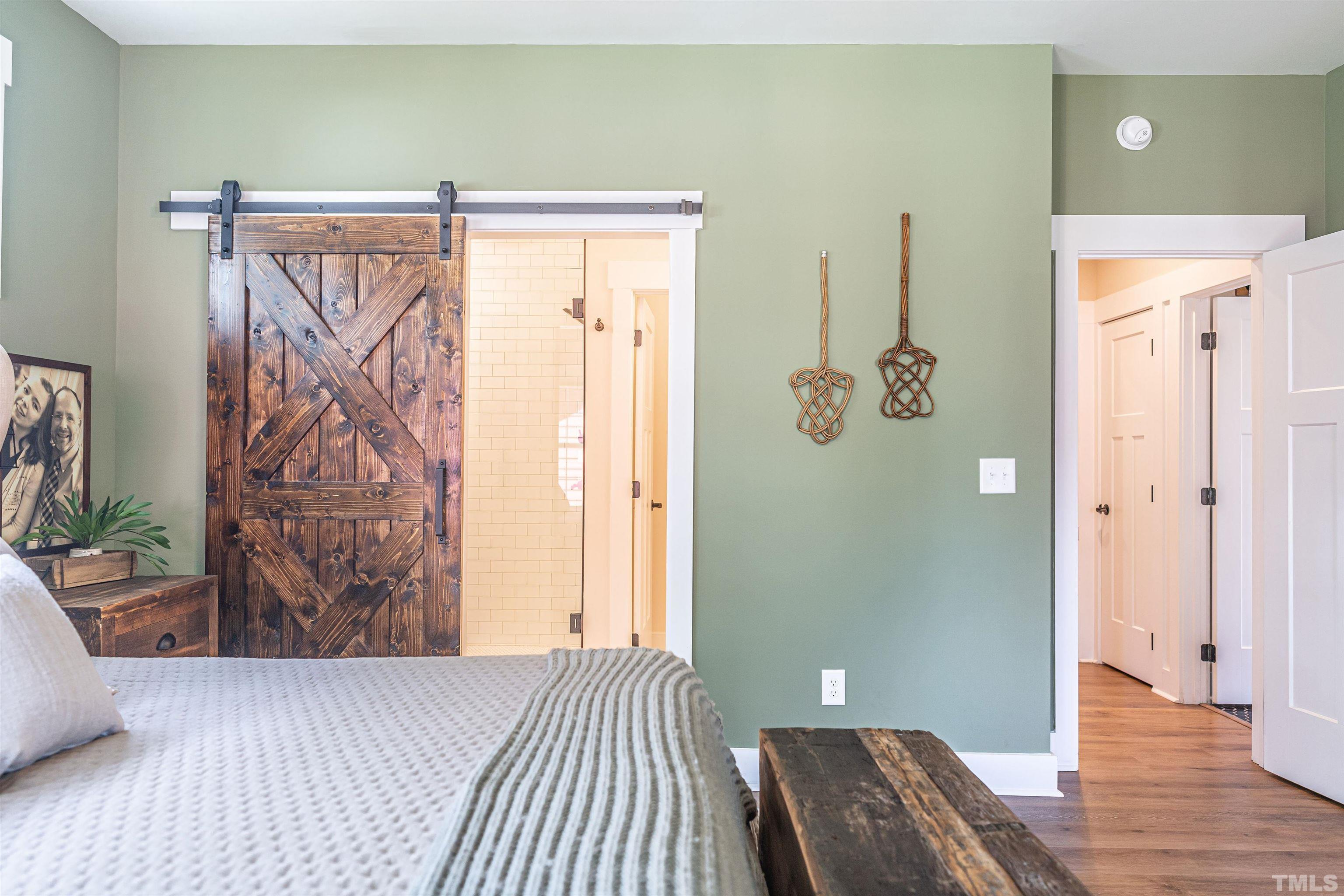 380 Sheldon Road Southern Pines, NC 28387 - Photo 17 of 32 a view of a bedroom with wooden floor and a chandelier