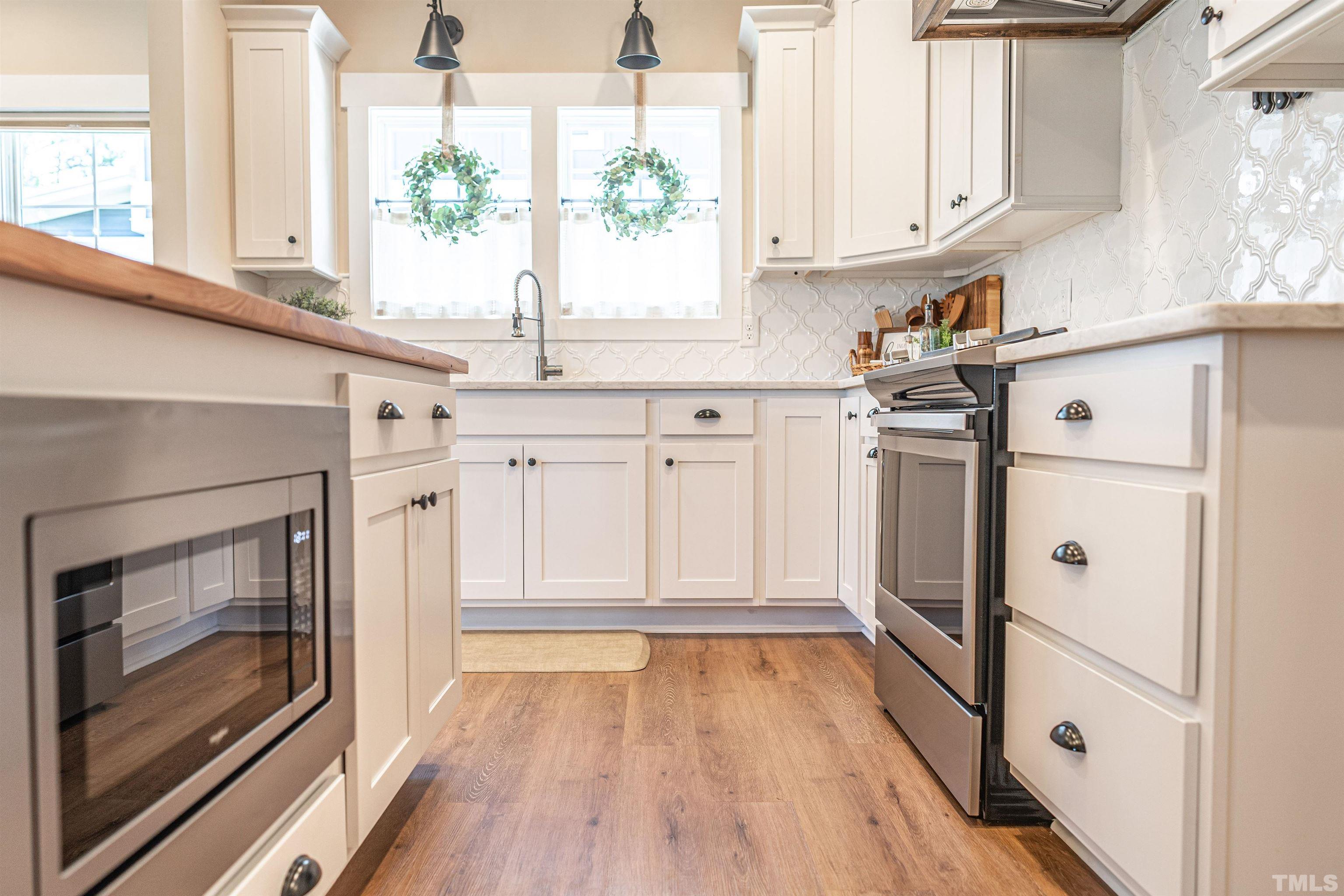 380 Sheldon Road Southern Pines, NC 28387 - Photo 8 of 32 a kitchen with granite countertop white cabinets and white appliances