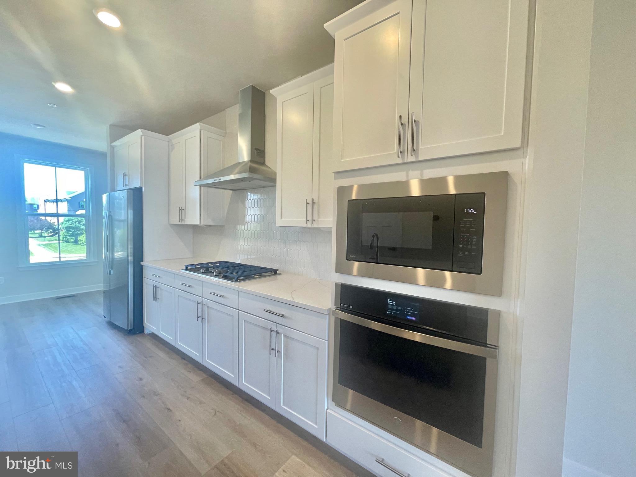 3563 Worthington Boulevard Frederick, MD 21704 - Photo 8 of 52 a kitchen with stainless steel appliances granite countertop a stove a microwave and a hard wood floors