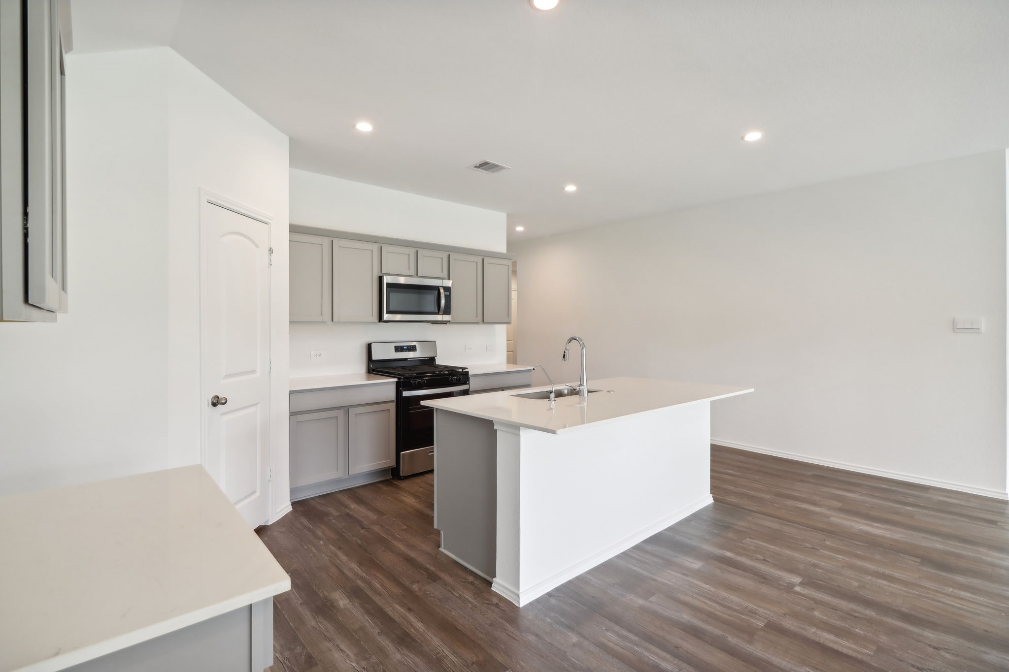 541 Wax Myrtle Way Hockley, TX 77447 - Photo 4 of 15 a kitchen with a sink cabinets stainless steel appliances and wooden floor