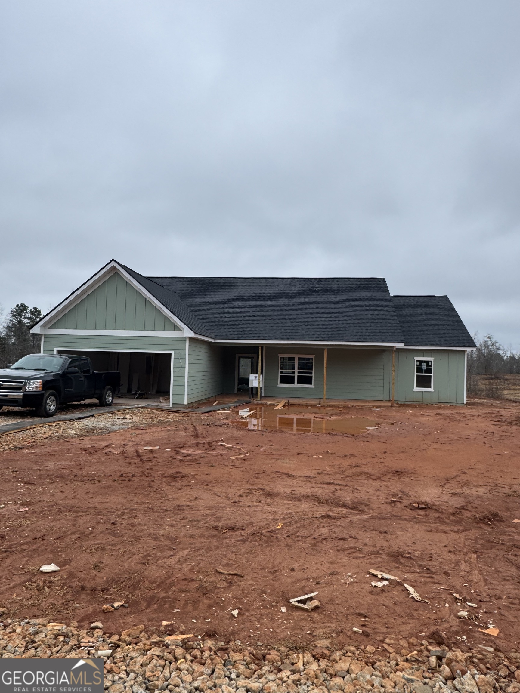 a front view of house with yard and trees in the background