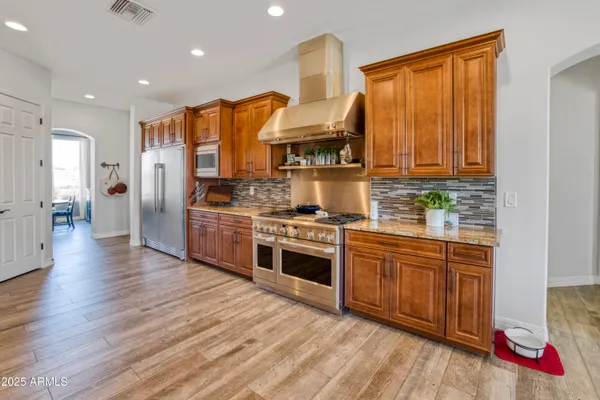 a kitchen with stainless steel appliances granite countertop a stove a sink and a refrigerator
