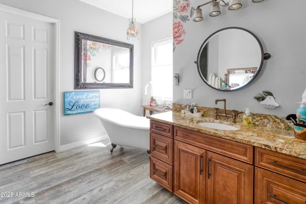 a bathroom with a granite countertop double vanity sink a mirror and a window