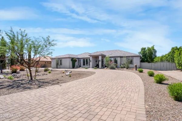 a front view of house with yard and trees in the background