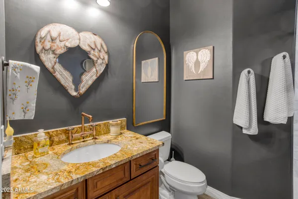 a bathroom with a sink vanity mirror and toilet