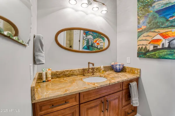 a bathroom with a granite countertop sink and a mirror
