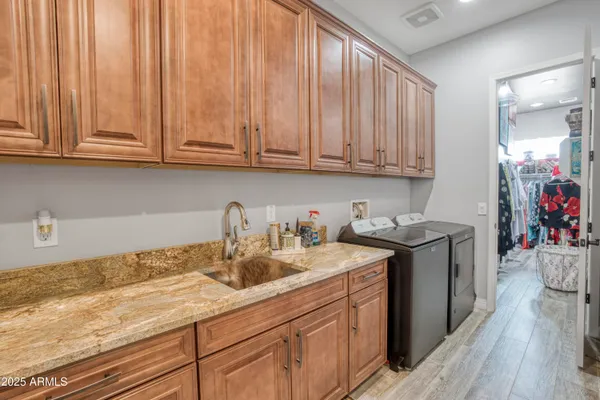 a kitchen with stainless steel appliances granite countertop a sink a stove cabinets and wooden floor