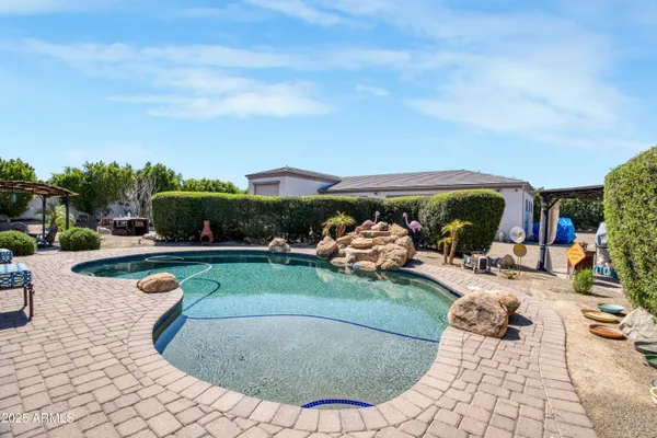 a view of a swimming pool with lawn chairs and a potted plants