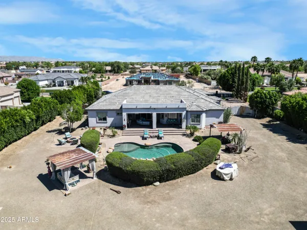 an aerial view of a house with swimming pool and a yard