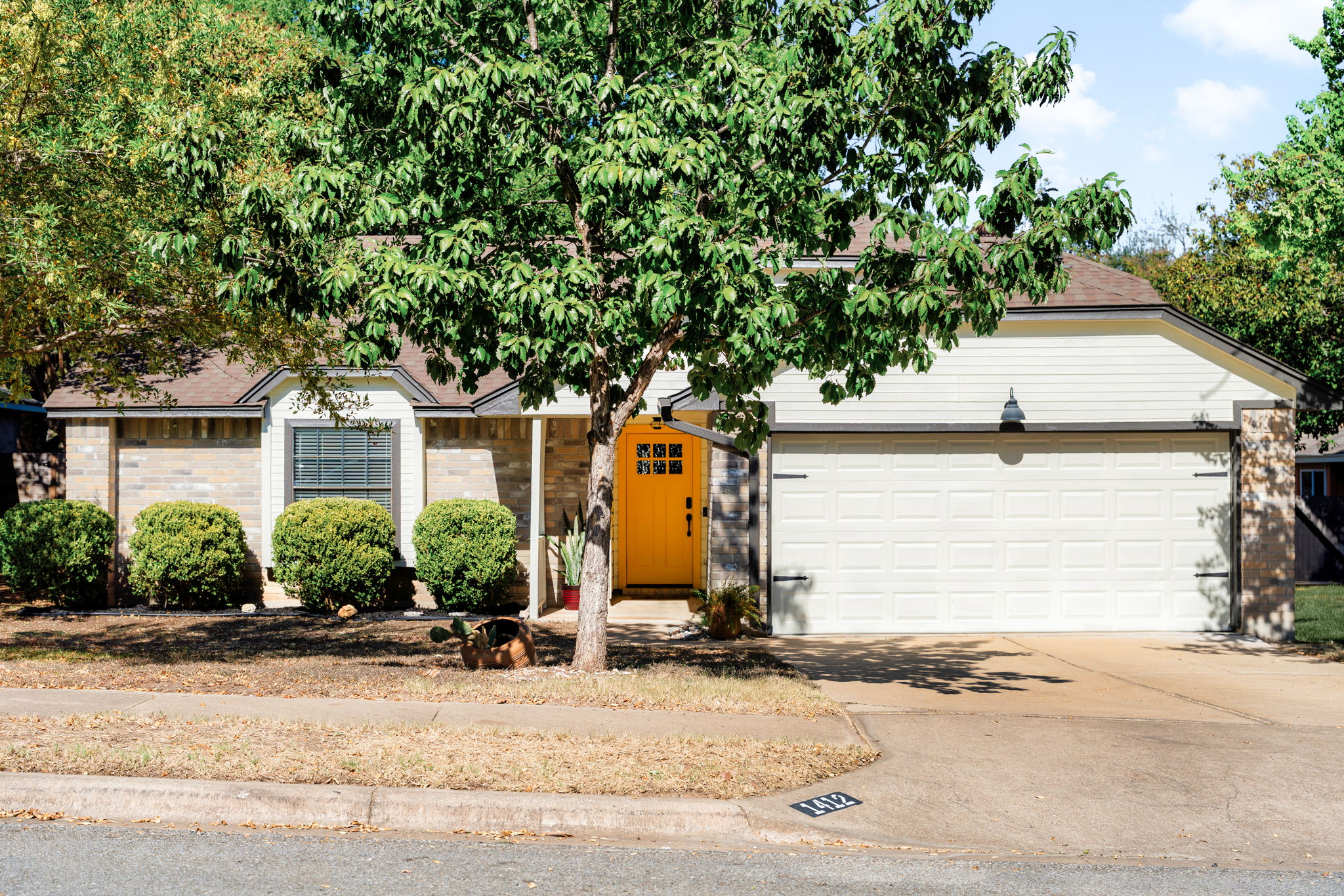 Ranch-style home featuring driveway, a garage, and brick siding