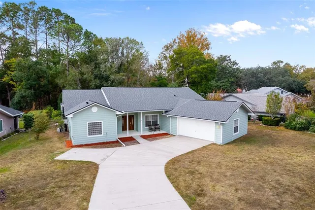 a aerial view of a house with a yard and large trees