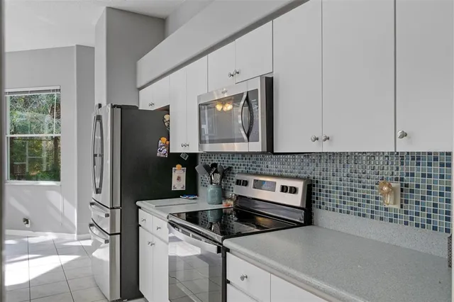 a kitchen with granite countertop a refrigerator stove and sink