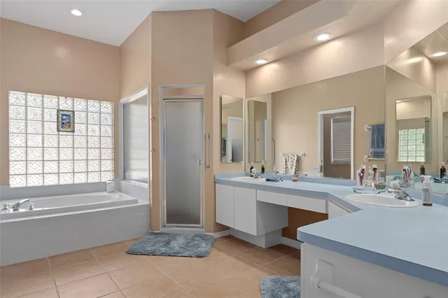 a bathroom with a tub a sink and a large mirror