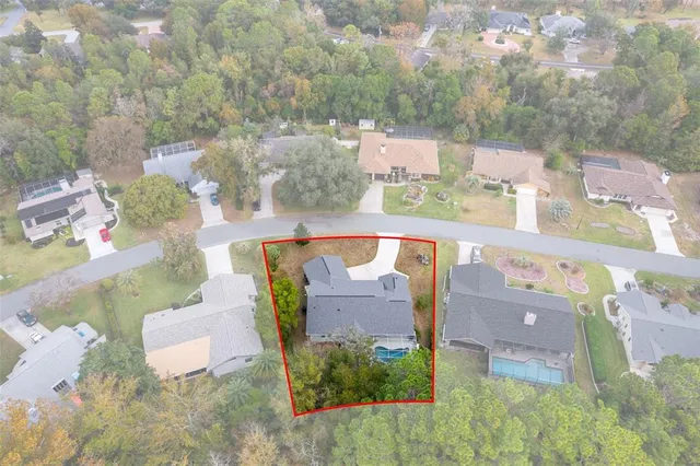 an aerial view of a house with outdoor space and a lake view in back