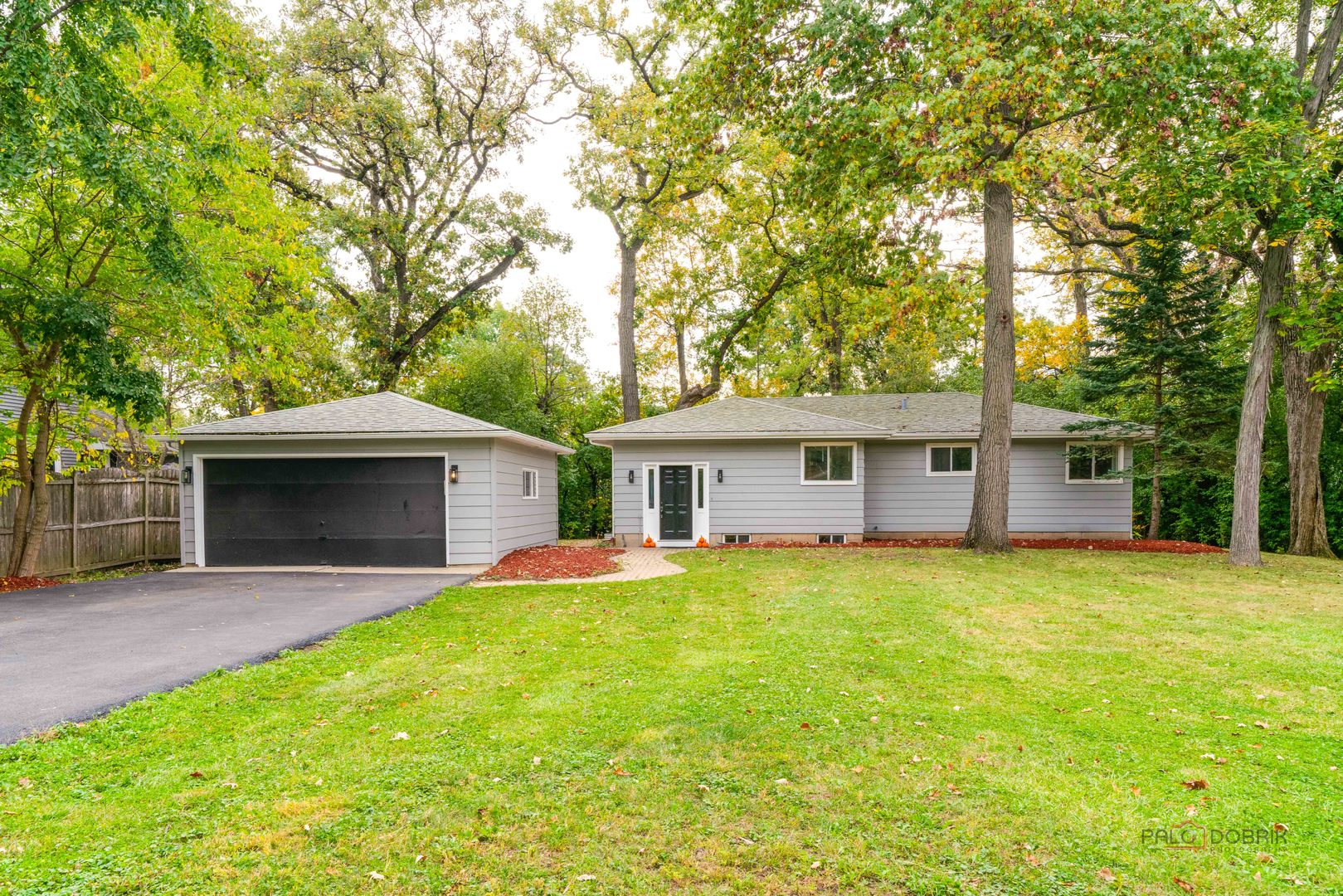 a front view of a house with yard and tree