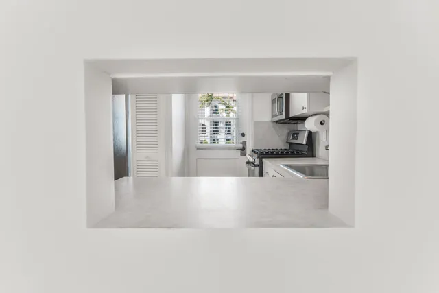 a large white kitchen with a large window