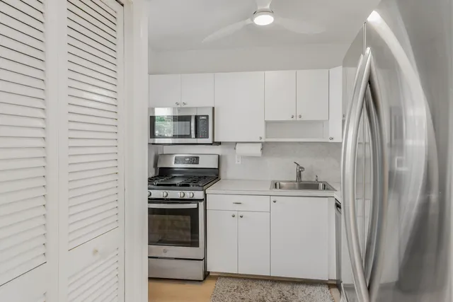 a kitchen with stainless steel appliances a refrigerator sink and microwave