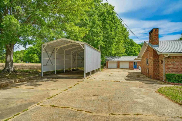 a view of a house with backyard and trees