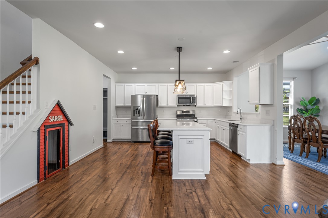 8200 Timberstone Drive Chesterfield, VA 23832 - Photo 12 of 42 a kitchen with stainless steel appliances kitchen island granite countertop a refrigerator a stove a sink dishwasher and white cabinets with wooden floor
