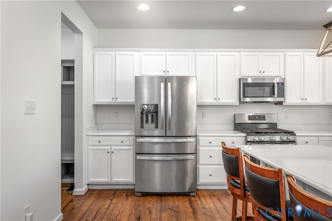 8200 Timberstone Drive Chesterfield, VA 23832 - Photo 16 of 42 a kitchen with stainless steel appliances white cabinets and a wooden floor