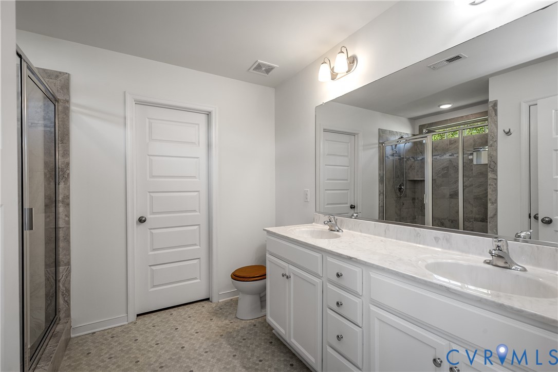 8200 Timberstone Drive Chesterfield, VA 23832 - Photo 30 of 42 a bathroom with a double vanity sink a mirror and a bathtub