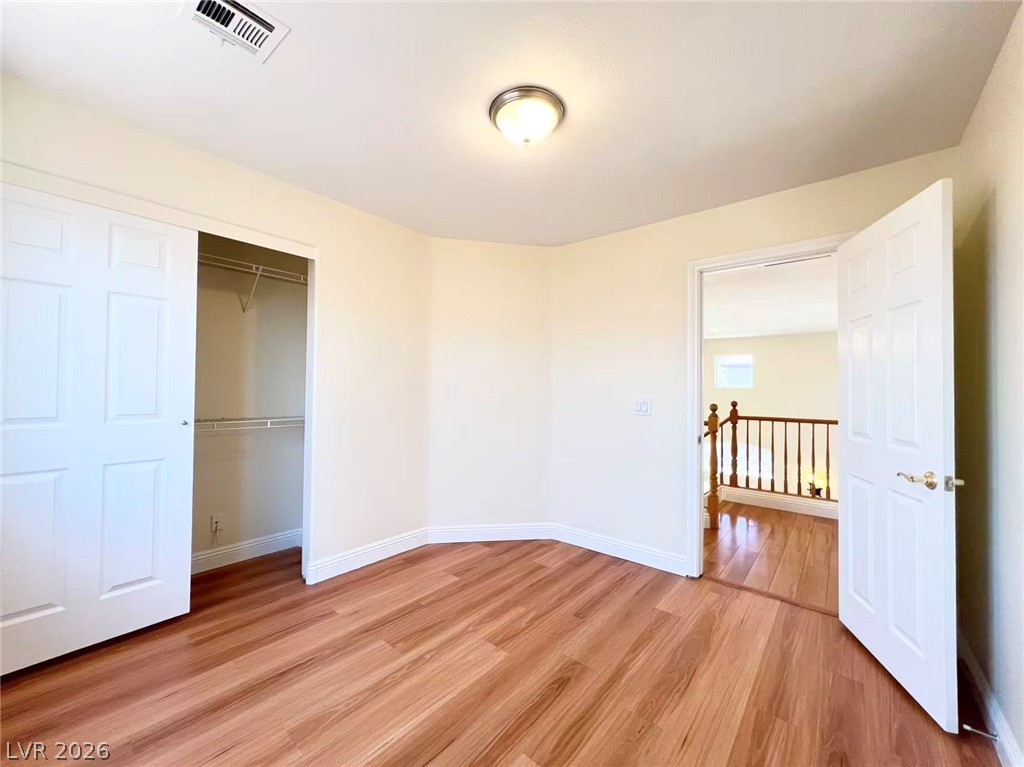 9891 Ridge Hill Avenue Las Vegas, NV 89147 - Photo 20 of 29 Natural wood flooring complements the bright walls and convenient closet space in this adaptable room.
