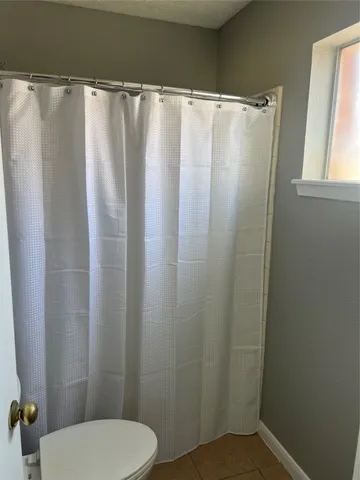 a bathroom with a granite countertop sink a toilet and a mirror