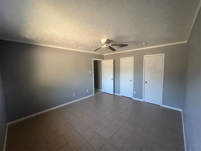 a white house with a big yard and large trees