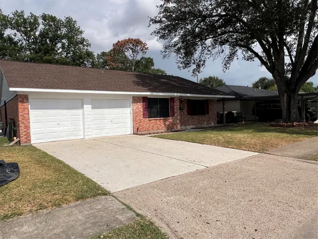 a front view of house with yard and trees in the background