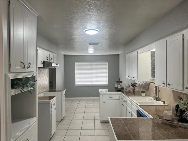 a kitchen with a sink cabinets and utility